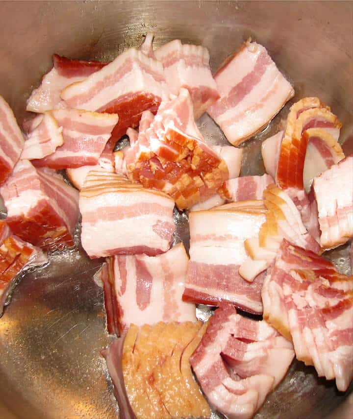 Cooking bacon in a pot to make green beans.