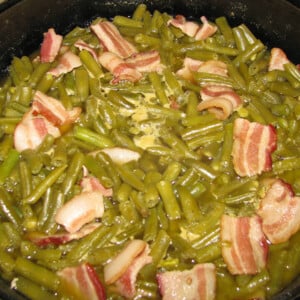 A photo of cooked southern green beans with bacon.