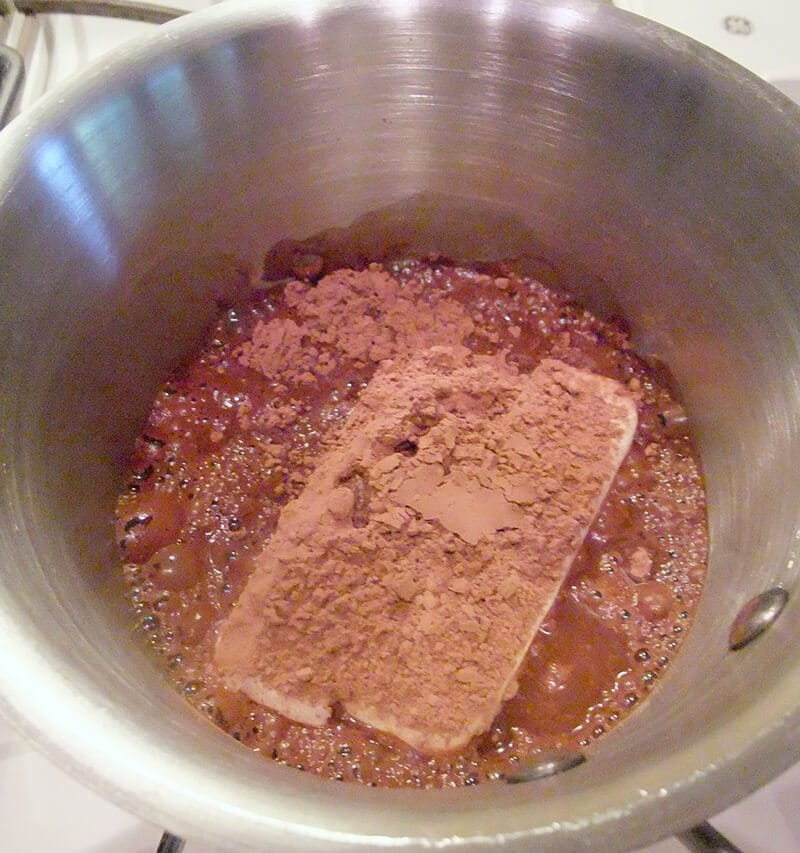 Chocolate sheet cake mixing butter and cocoa in saucepan