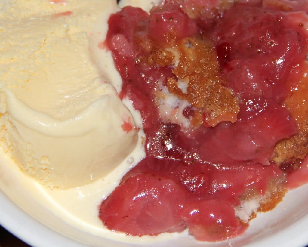 Strawberry Cobbler in a bowl with vanilla ice cream. 