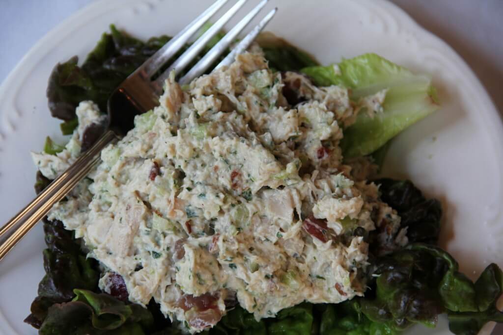 Serving of finished chicken salad with grapes on a plate with a fork.
