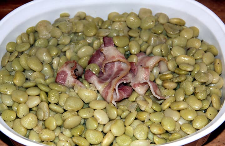 Butter beans in a dish with bacon cooked.