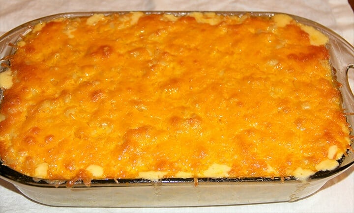 A dish of baked macaroni and cheese ready to serve is the ultimate Southern food to cook at home.