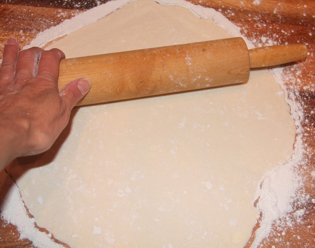 Rolling out pie crust with a rolling pin.