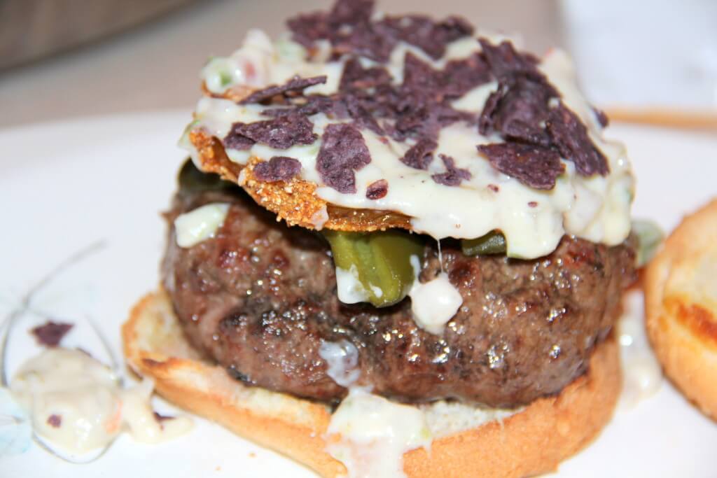 santa fe burger with fried green tomato, chips, queso, and poblano peppers.