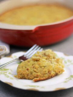 A serving of Southern cornbread dressing on a plate with dish in background.