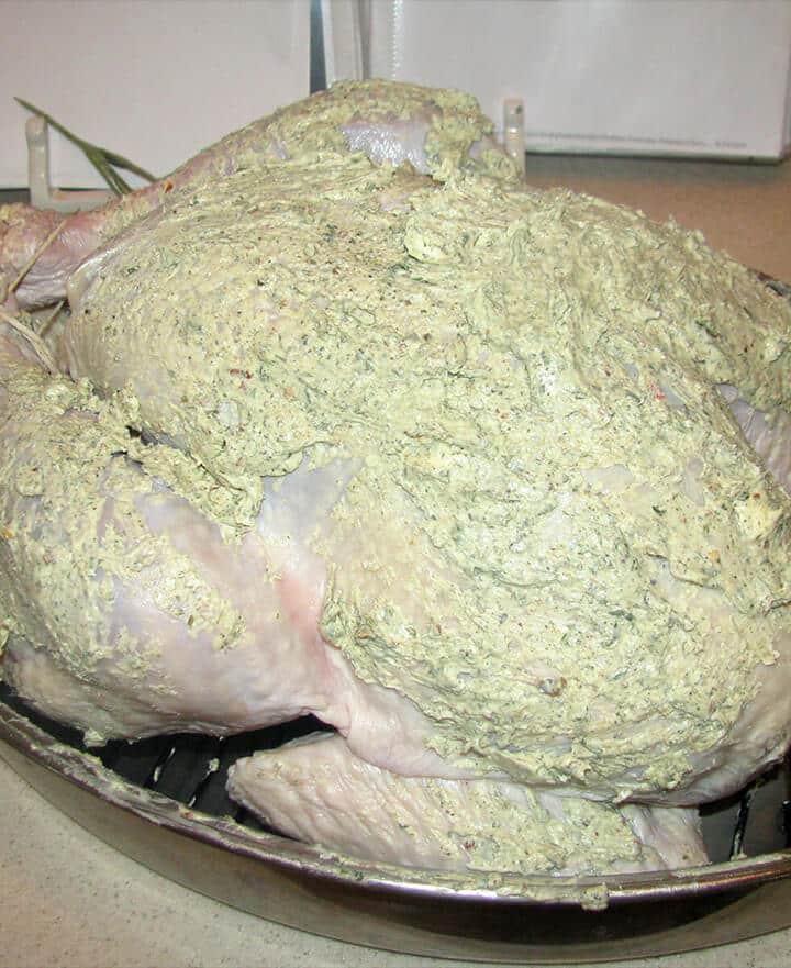 A turkey rubbed with herb butter made from fresh herbs.