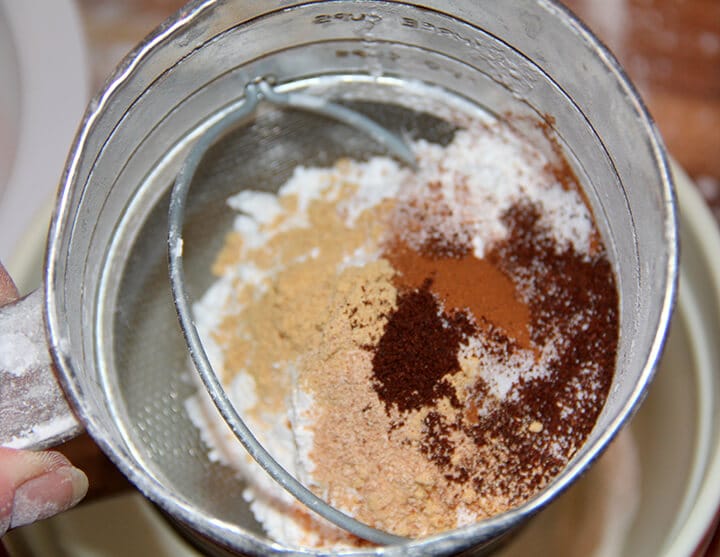 Spices and flour in a sifter for making pumpkin roll.