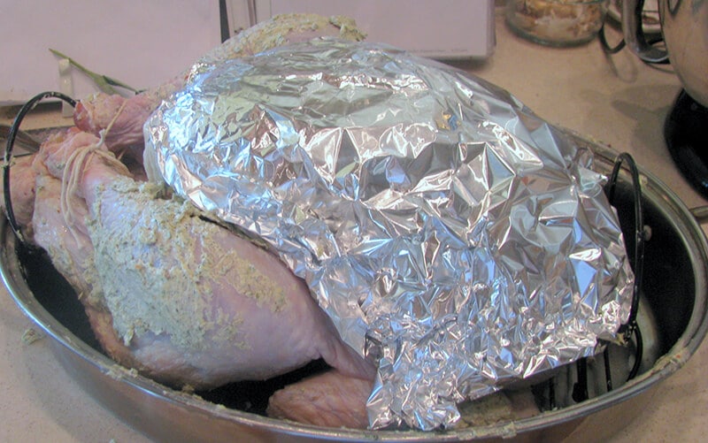 Turkey ready to roast with breast covered in foil. 