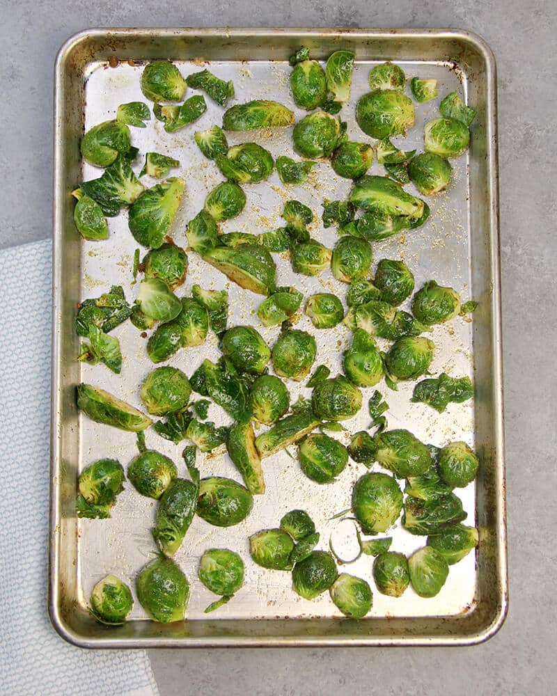 Sliced and chopped brussels sprouts on a baking sheet. 
