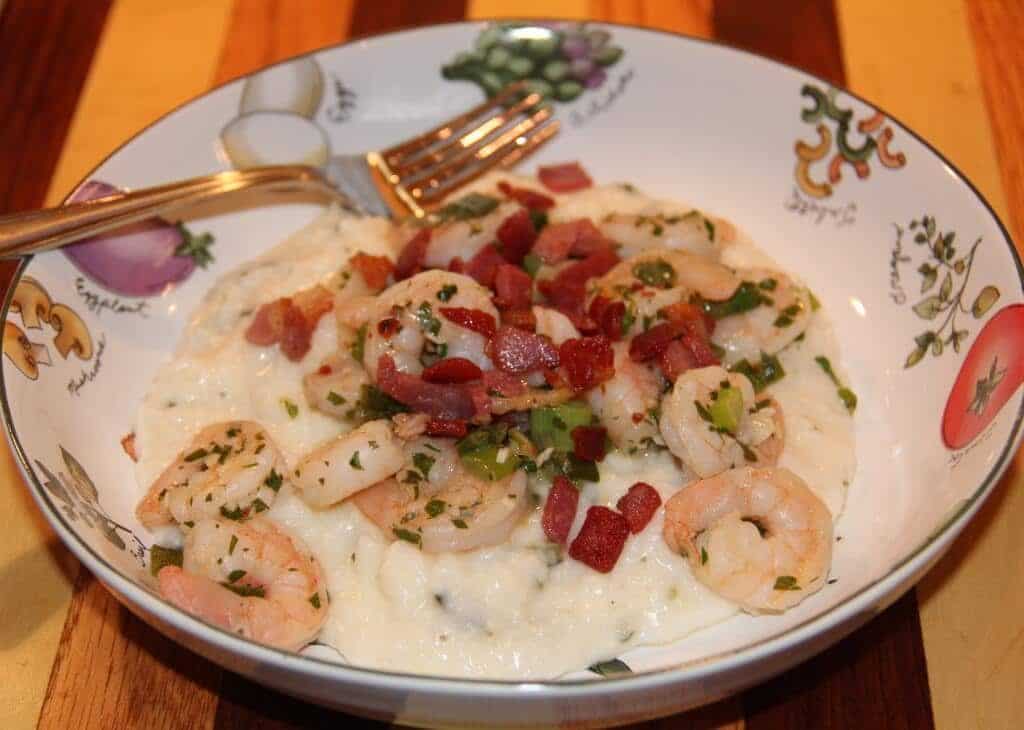 A bowl of shrimp and grits with a fork.
