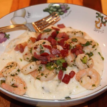 A bowl of shrimp and grits with a fork.