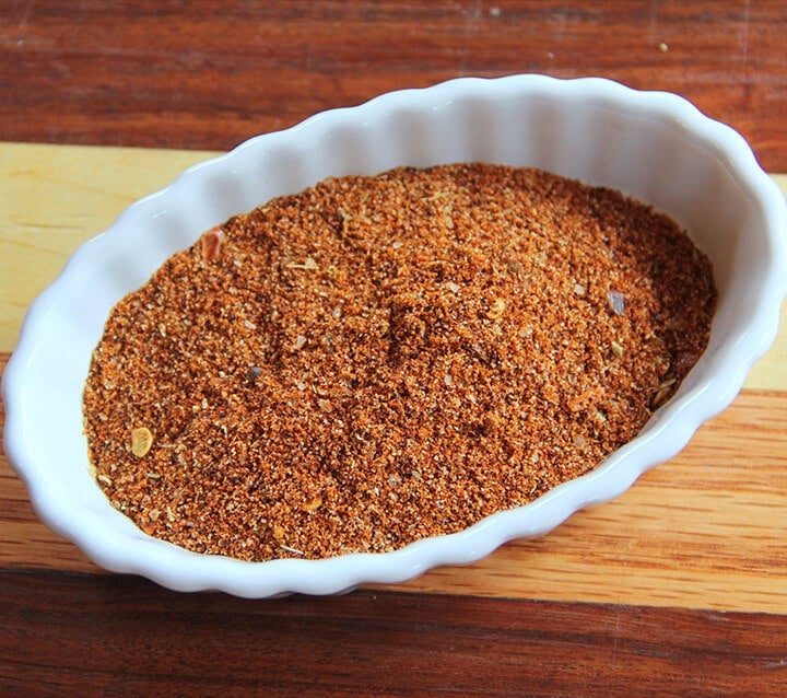 A bowl of homemade taco seasoning on a board.