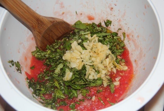 Stir garlic and basil into fresh crushed tomatoes. 