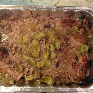A foil pan filled with roast beef.