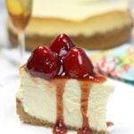 Side view of a slice of new york-style cheesecake with strawberries on top.
