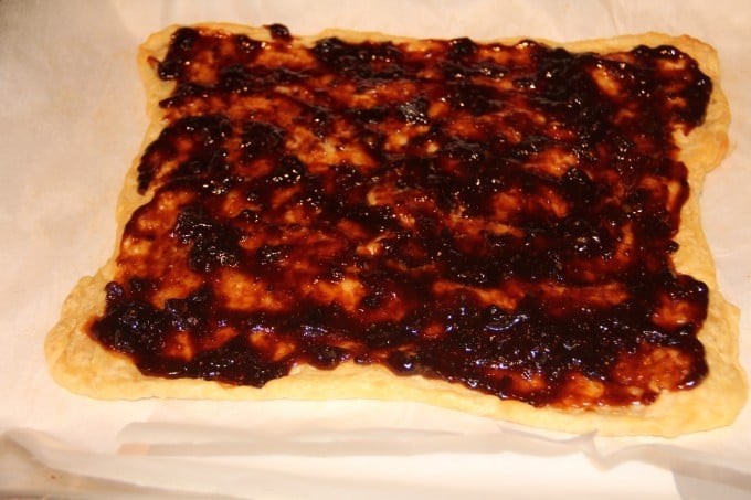 spreading fig jam on pizza crust