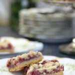 Raspberry Bars made with a buttery shortbread base and topped with easy raspberry filling and a yummy shortbread streusel sprinkled on top. They are divine.