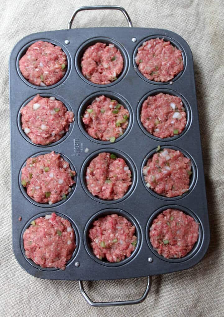 Prebaked meatloaf muffins portioned in a muffin pan.