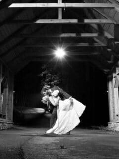 bride and groom under the covered bridge