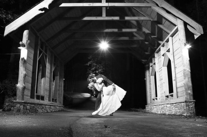 bride and groom under the covered bridge