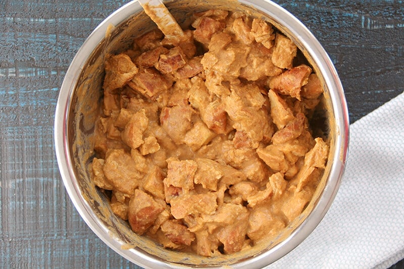 Large bowl full of bread cubes and pumpkin mixture for the pumpkin bread pudding. 