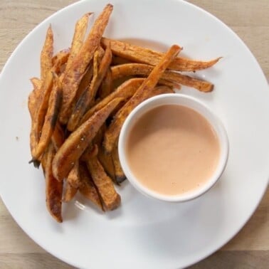plate of sweet potato fries with sriracha sauce