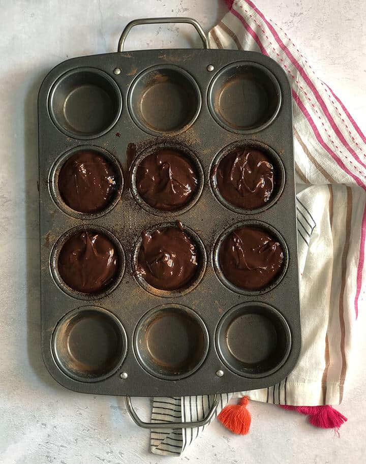 Muffin pan filled with batter for chocolate lava cakes.