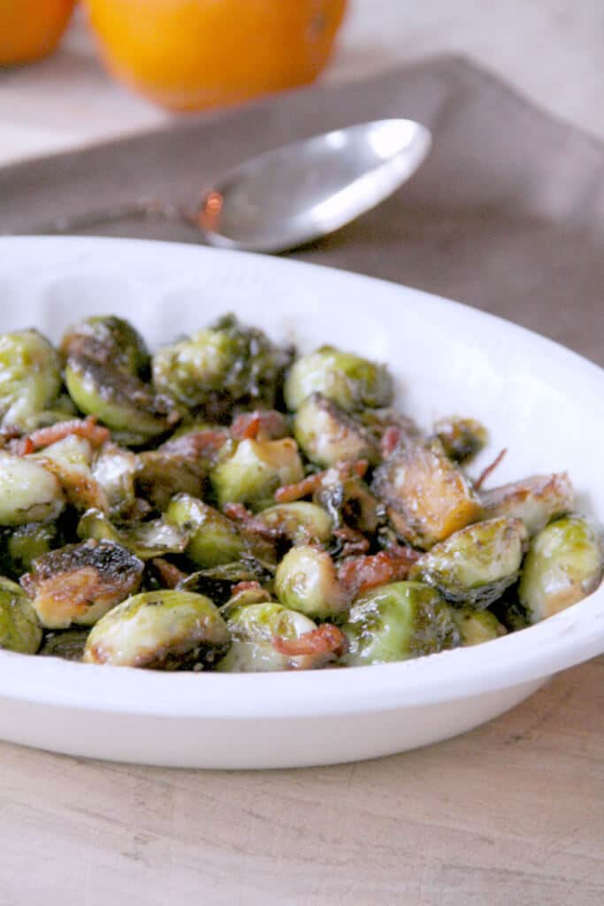 Savory sweet maple and balsamic glazed brussels sprouts with crispy bacon is a tasty side dish.