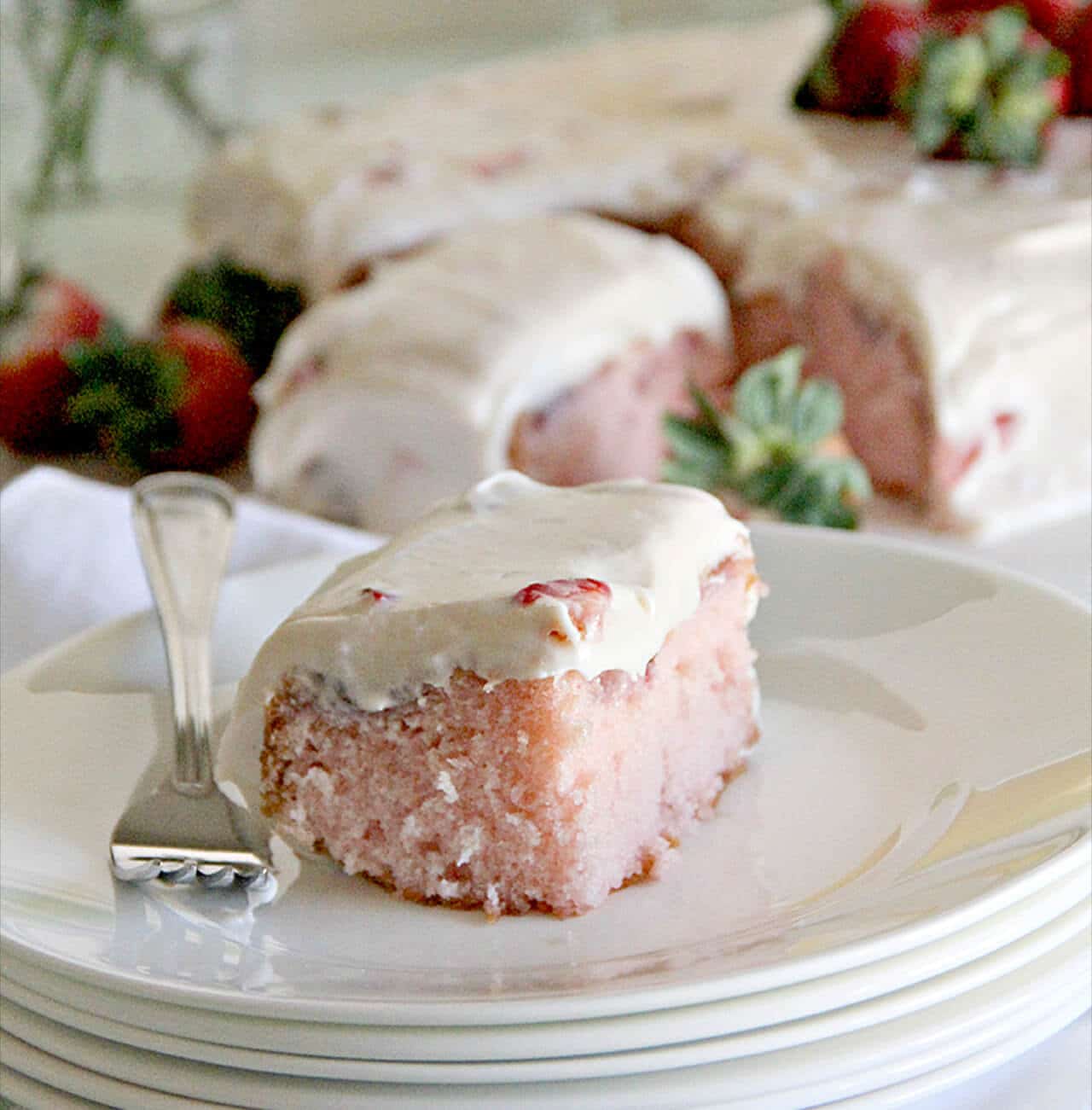 A luscious strawberry sheet cake with fresh strawberries and cream cheese frosting that's always a crowd-pleaser and easy to take along for potlucks.