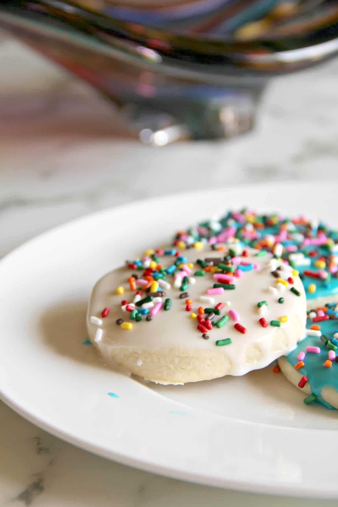 A delicious and easy sugar cookie recipe with simple icing that's quick and easy to apply. And sprinkles, of course! Kids love these cookies.