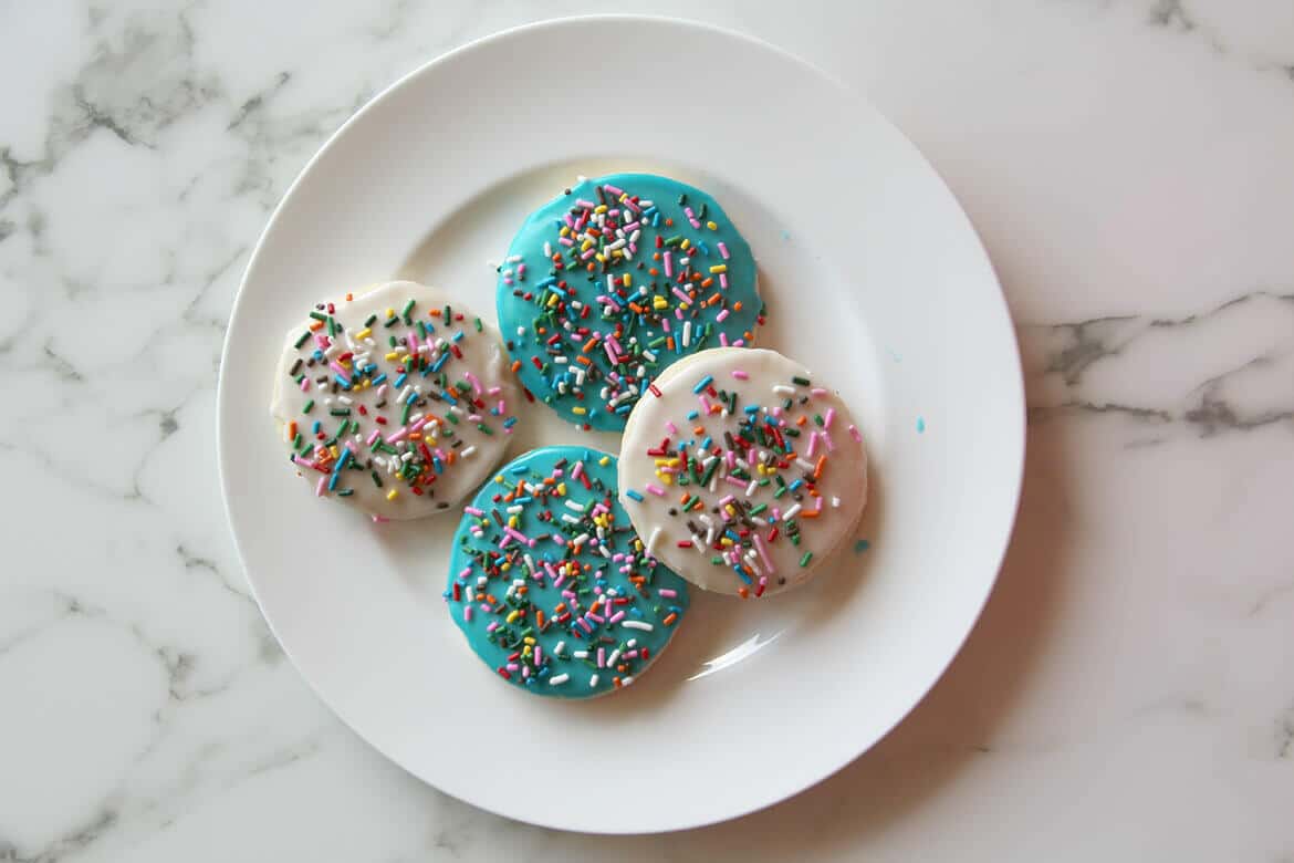 A delicious and easy sugar cookie recipe with simple icing that's quick and easy to apply. And sprinkles, of course! Kids love these cookies.