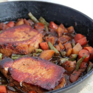 A pan filled with meat and vegetables, with Pork Chop.
