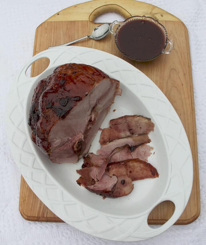 Sliced cherry glazed ham on a platter.
