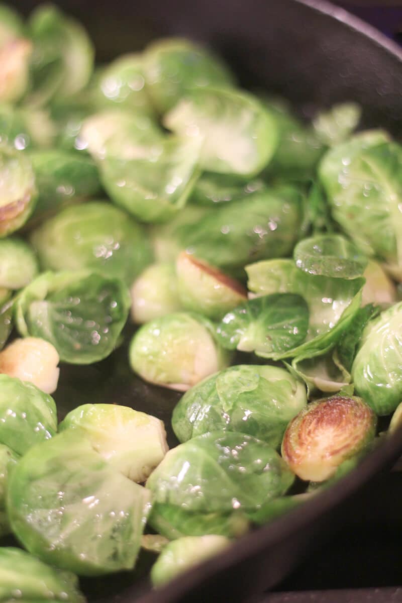 A side view of brussels sprouts in a skillet ready to cook.