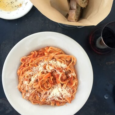 A bowl of pasta next to bread and olive oil from Figo's Pasta in Best Places to Eat in Atlanta.