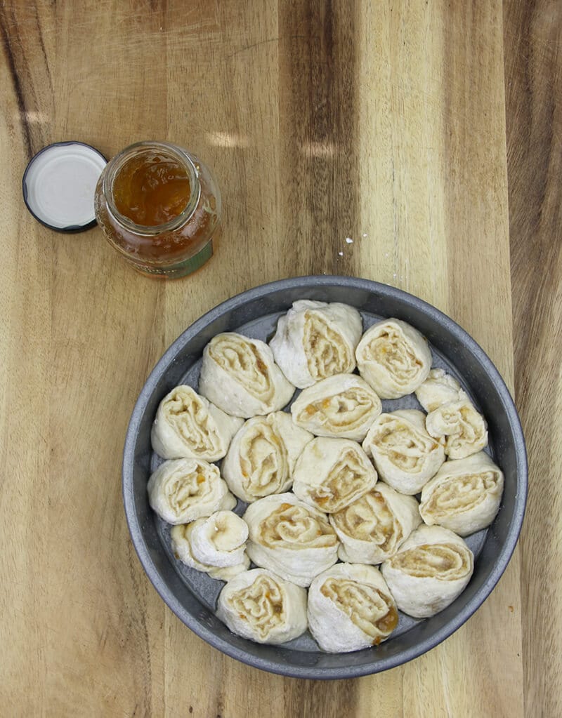 Orange rolls in cake pan ready to bake.