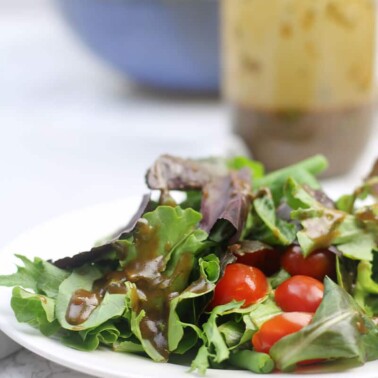 Balsamic Vinaigrette over salad on plate.