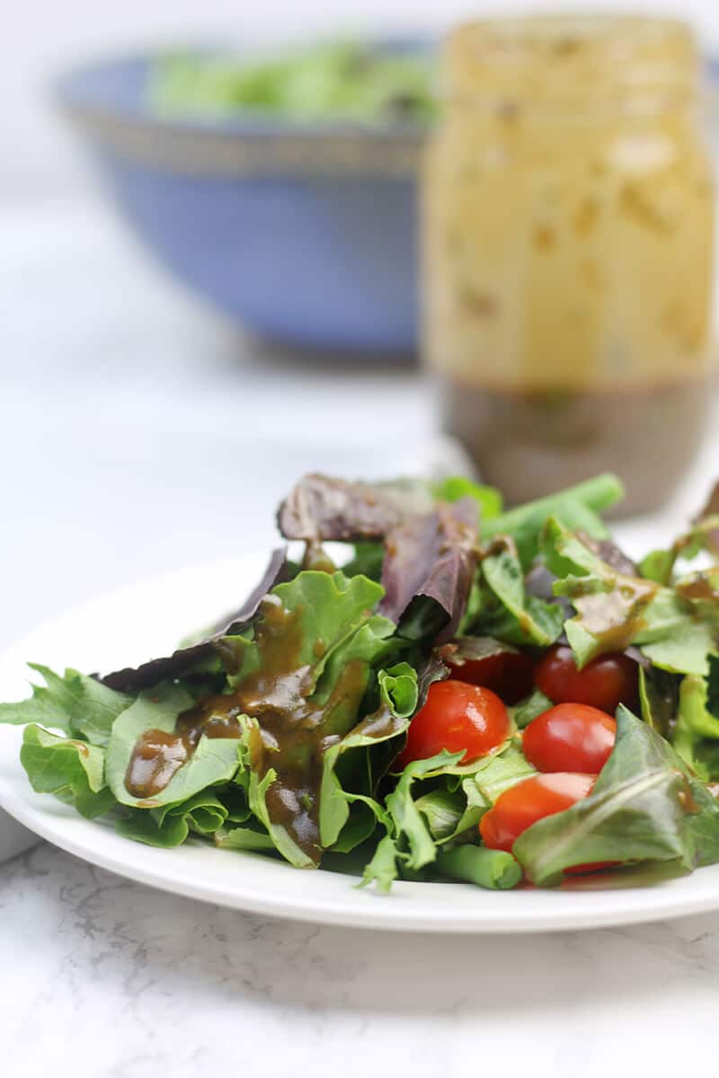 Balsamic Vinaigrette over salad on plate.