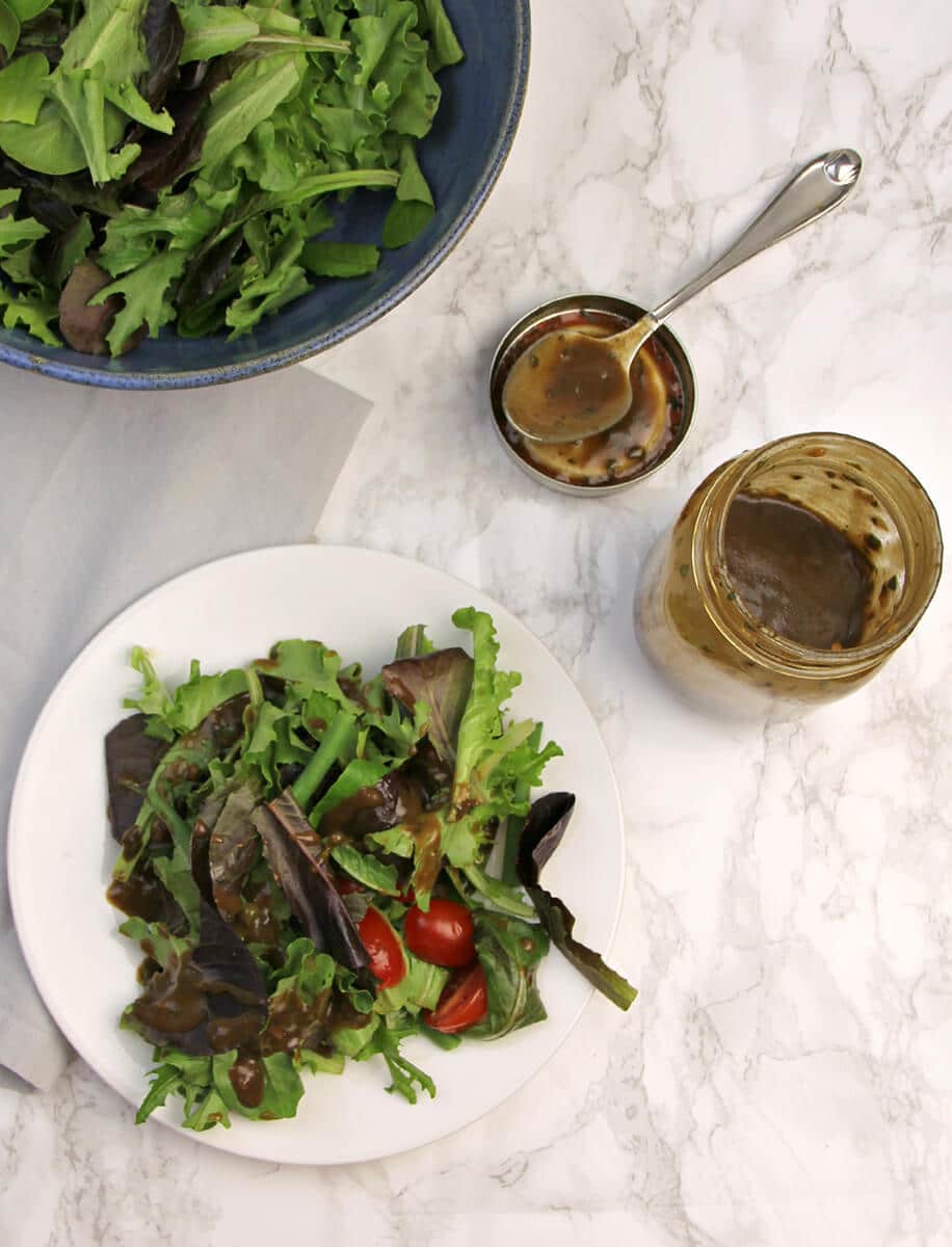 Balsamic Dressing over salad on table. 