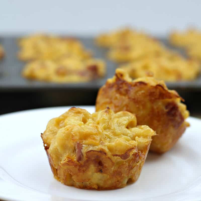 Mac and cheese muffins with ham on a white plate.
