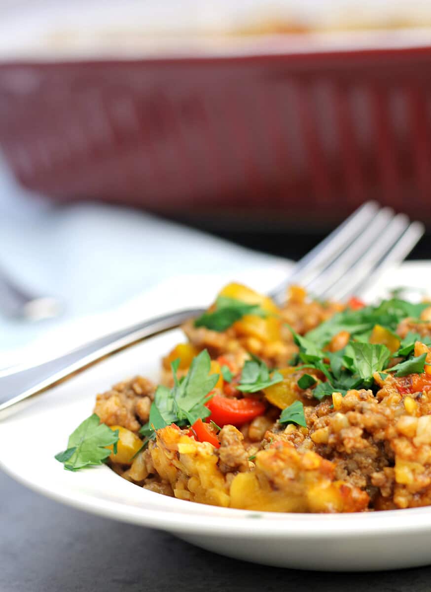 A serving of Unstuffed Pepper Casserole in a shallow bowl with a fork. 