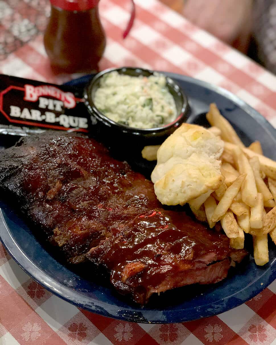 A plate of ribs, fries, slaw, and biscuit from Bennett's BBQ in Pigeon Forge.