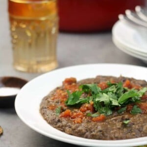 Easy Black Bean Soup in a white bowl garnished with cilantro and salsa.