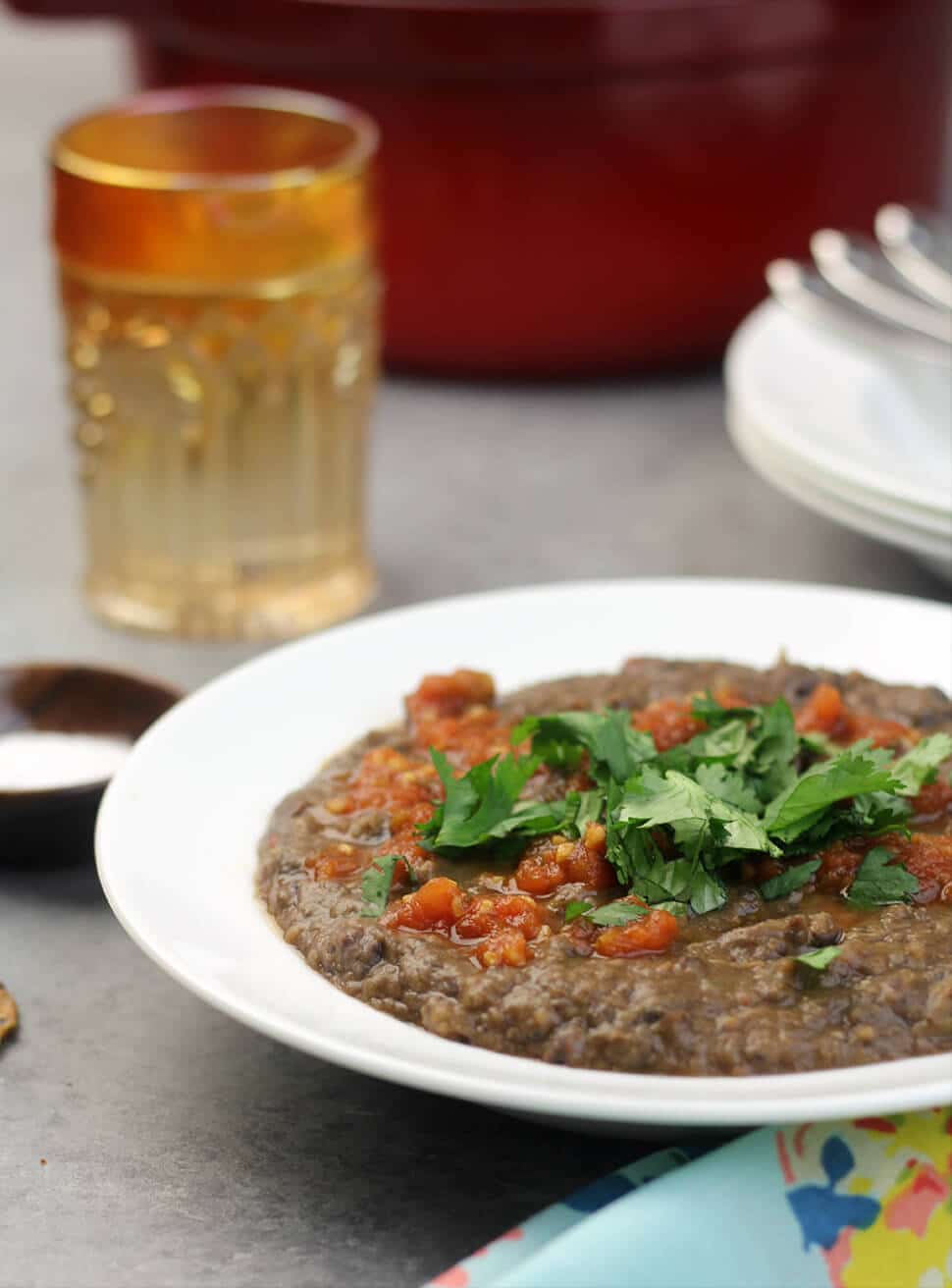 Easy Black Bean Soup in a white bowl garnished with cilantro and salsa. 