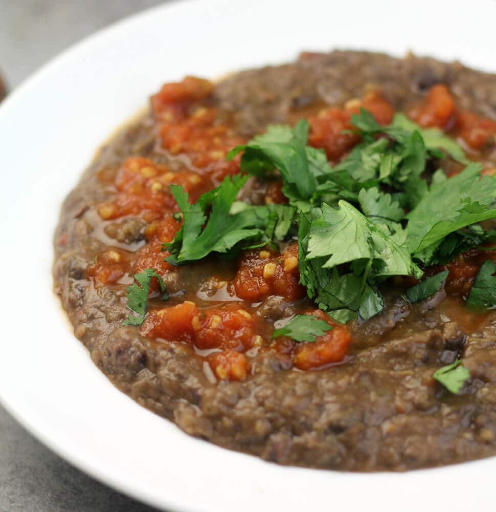 a bowl of black bean soup garnished with parsley