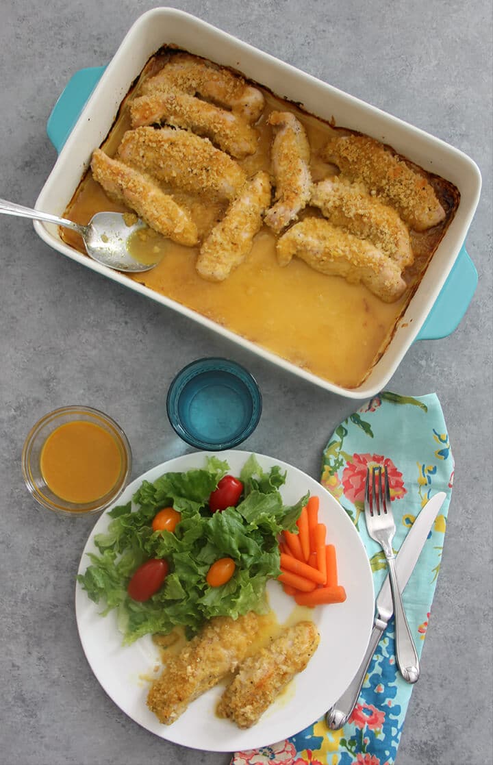Overhead picture of honey mustard chicken tenders on a plate and the baking dish. 