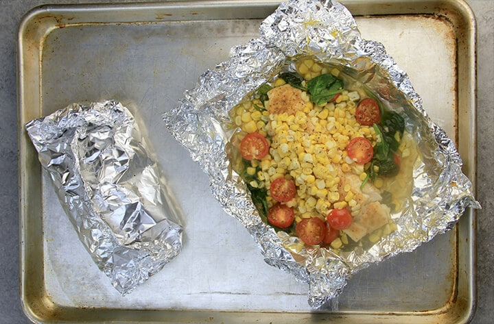 Foil packets on baking pan after cooking. 