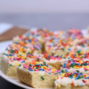 Sugar Cookie Bars with sprinkles and frosting on a plate.
