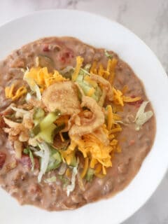 Closeup photo of a bowl of bacon cheeseburger soup with toppings.